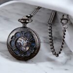 Montre à gousset vintage Matheo posée sur une table en marbre avec sa chaine