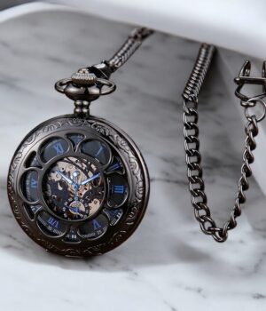 Montre à gousset vintage Matheo posée sur une table en marbre avec sa chaine