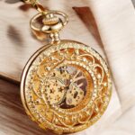 Présentation complète de la montre Stella Or avec cadran étoilé sur fond noir, chaîne en laiton et détails soignés.