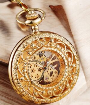 Présentation complète de la montre Stella Or avec cadran étoilé sur fond noir, chaîne en laiton et détails soignés.