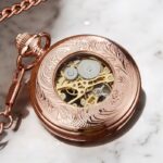 La montre à gousset Roséa posée avec sa chaîne assortie, montrant son design vintage et raffiné.