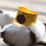 Bague dorée Jane portée, mettant en valeur son design élégant