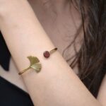 Zoom sur le bracelet jonc doré Stela montrant sa texture raffinée et sa couleur dorée élégante avec éléments en bois d’amarante.