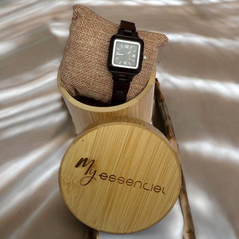 Coffret en ébène collection Mélissa My Essenciel contenant une montre en bois femme posée sur son coussin en toile naturelle, avec maillons supplémentaires.
